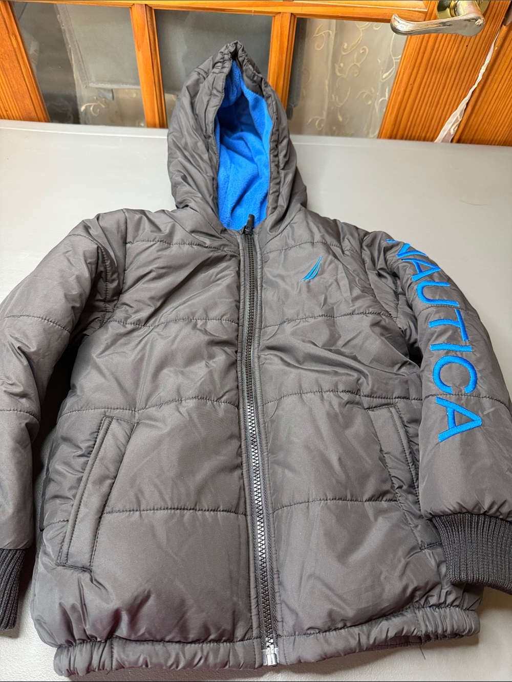 Kid’s Nautica Black Puffer Jacket with Blue Fleece Lining. Size: 5